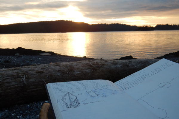 notebook with sunset behind