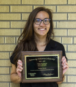 Maria holds Advancing Education Scholarship plaque