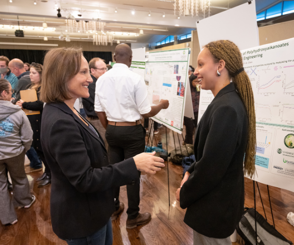 Director of CSU Writes speaks with student at GradShow